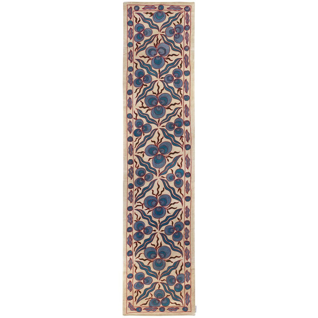 Front view of Mekhann's cream cintamani runner, displaying a full collection of hand embroidered cintamani patterns and other decorative motifs that cover the entirety runner, all of them have been had embroidered in blue silk yarns on a base of cream coloured silk.