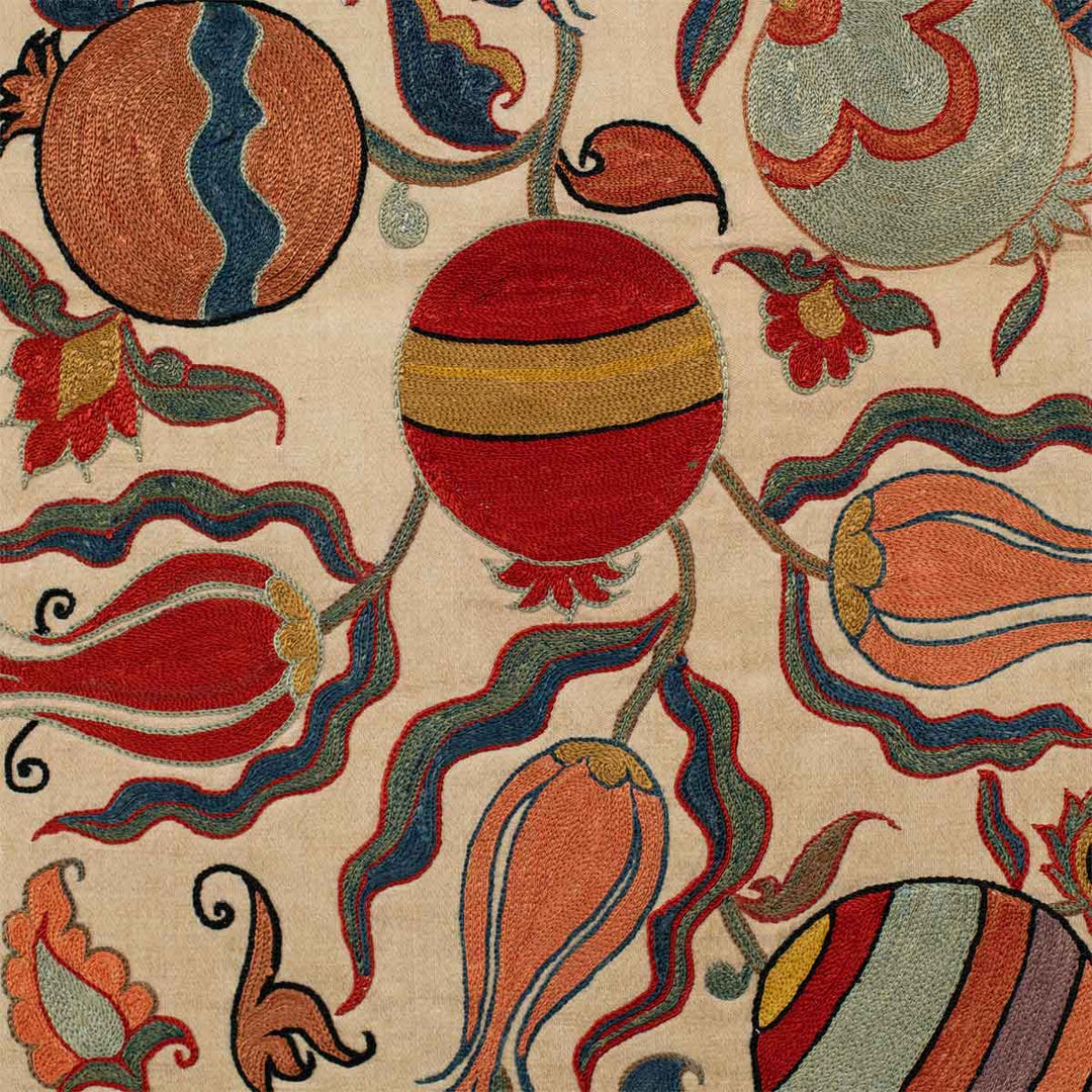 Detailed view of Mekhann's cream ottoman vines runner, showing up close the embroidered details created in bright colours that stand out of the cream silk background.