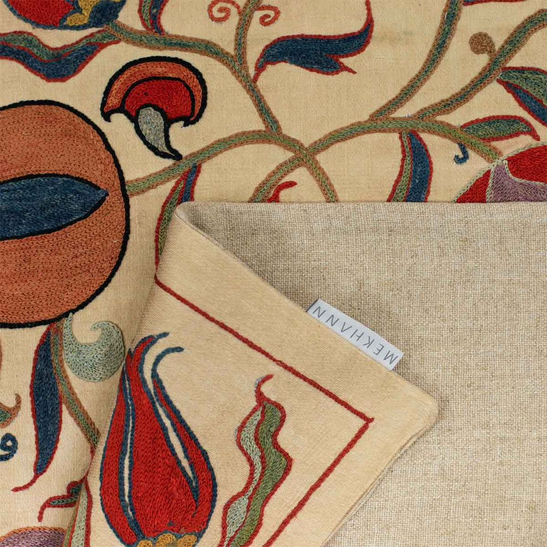 Folded view of Mekhann's cream ottoman vines runner, showing the beige colour of the back linen of the runner with the Mekhann label attached.