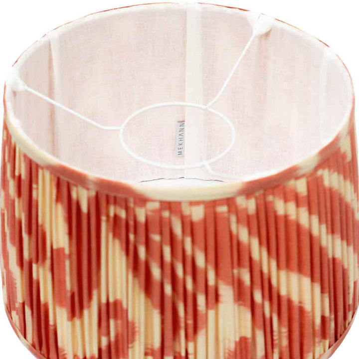Interior view of Mekhann's cream and orange ikat lampshade, displaying the delicate silk fabric and vibrant hand-dyed pattern.