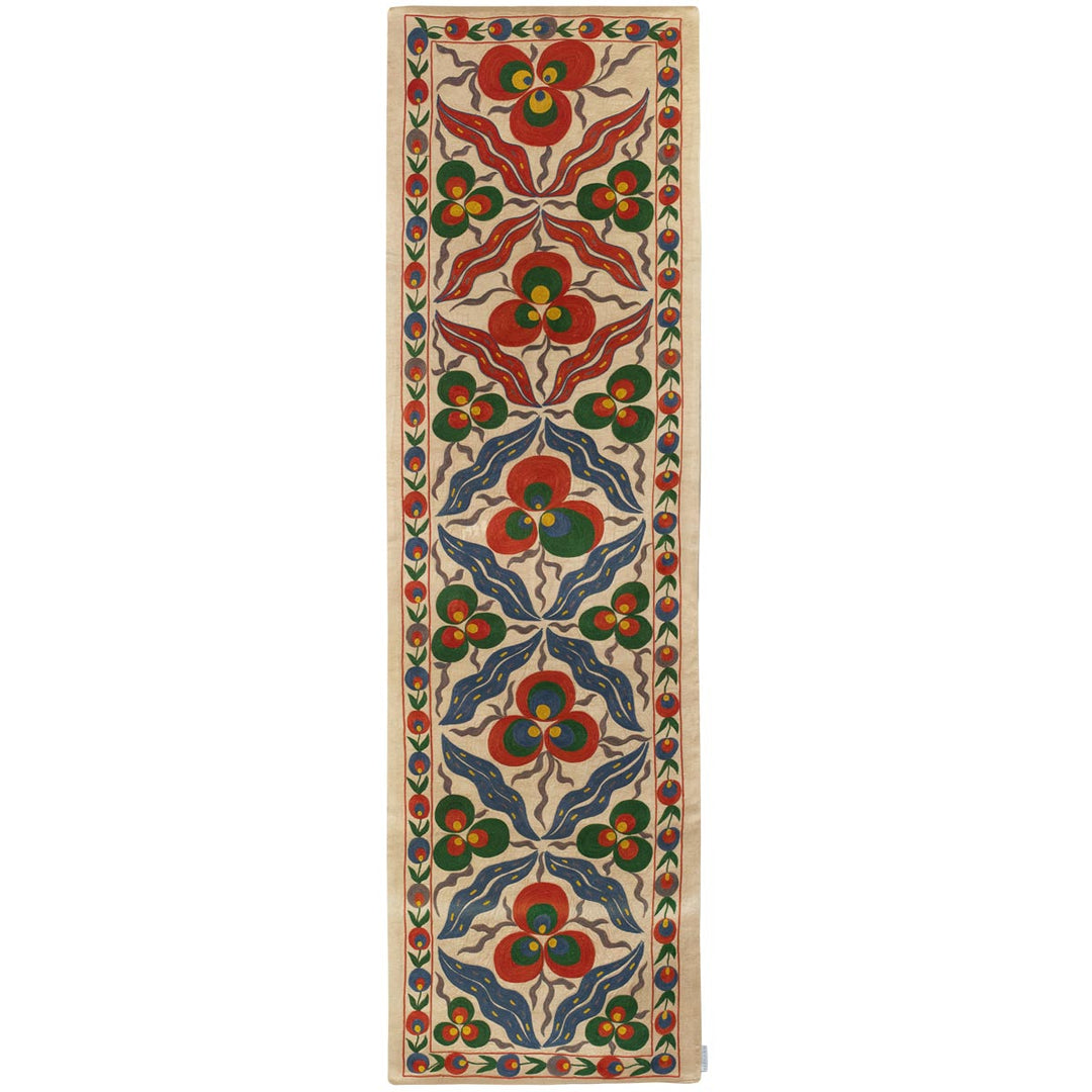 Front view of Mekhann's cream cintamani runner, displaying a full collection of hand embroidered cintamani patterns and other decorative motifs that cover the runner entirely, all set on a canvas of cream coloured silk.