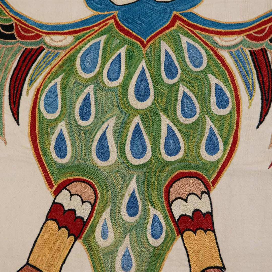 Close-up of handcrafted silk throw by MEKHANN, featuring double-headed eagle with peacock-inspired tail, vibrant embroidery, perfect for elegant home styling.