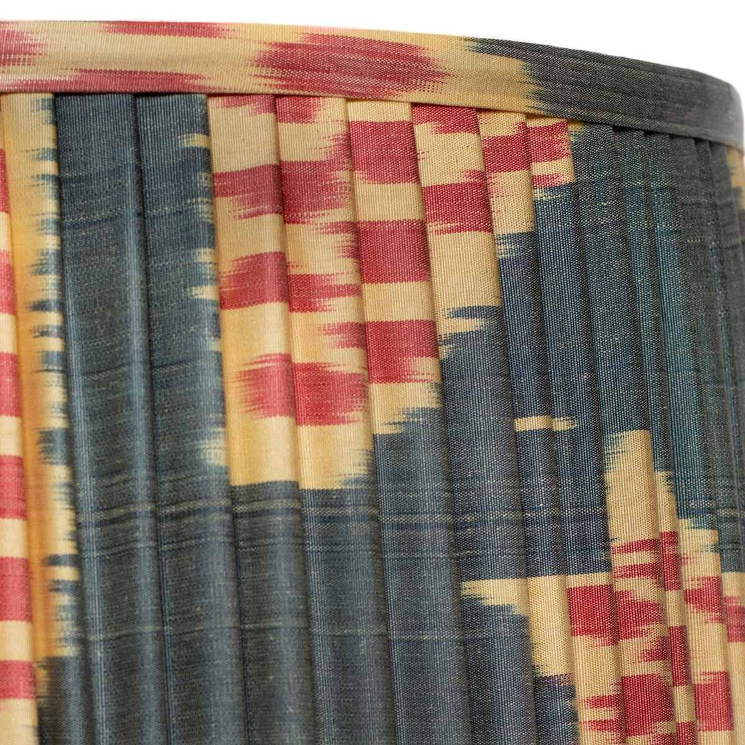 Close-up of the Echo Pewter silk ikat lampshade showing the silk weave, hand-pleated surface and patterned trim.
