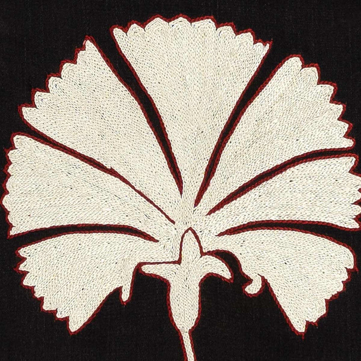 Close up view of Mekhann's black and white carnations embroidered silk artwork, displaying a white embroidered carnation with a delicate red outline to make it stand out even more against the black silk background.