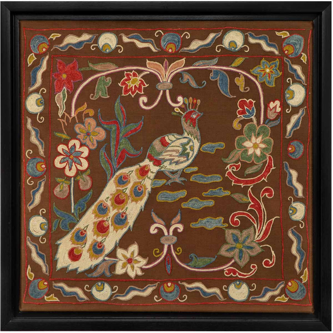 Front view of Mekhann's brown silk peacock artwork, showing a silk brown background with a peacock and flowers in a collection of vibrant colours, all set within an elegant black frame.