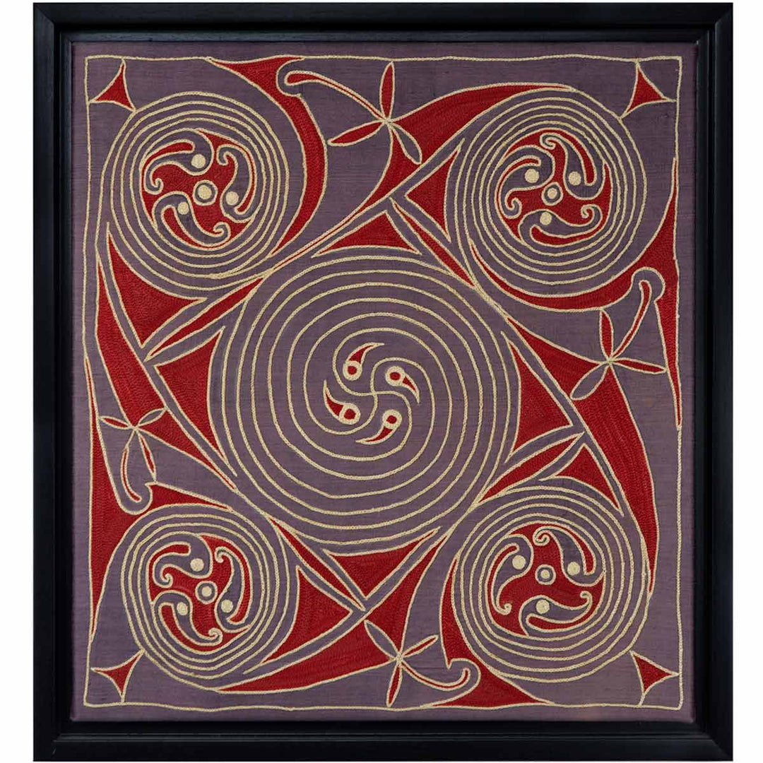 Front view of Mekhann's dark purple and red silk embroidered spirals artwork, with a display of bold swirls and abstract shapes in cream and red on a dark purple silk background, framed in black.