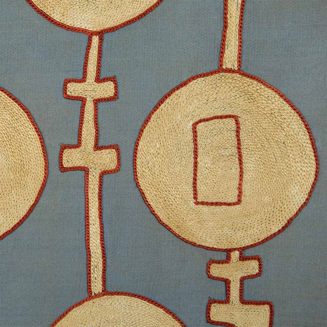 Close up view of Mekhann's grey silk embroidered tent artwork, where the precision of the cream and red silk yarns can be seen against the grey silk can be seen up close.