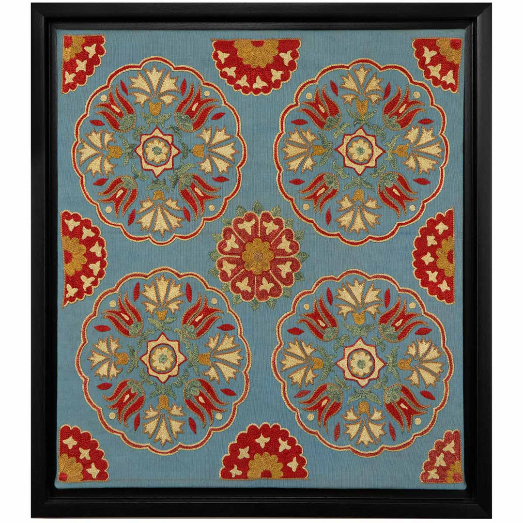 Front view of Mekhann's grey silk hand embroidered spirals artwork, showing four main spirals with floral detail in the negative space, all within a black frame.