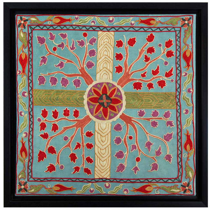 Front view of Mekhann's grey tree of life silk embroidered artwork, featuring the four embroidered  Tree of Life motifs coming from the centre, set against a grey silk background, with rich hues of red and purple florals branching out, enclosed in a black frame.