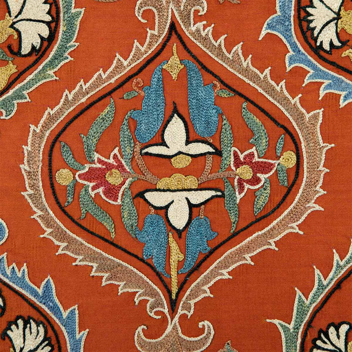 Close up view of Mekhann's maroon silk embroidered artwork, focusing on the embroidered patterns and colour contrasts, showcasing the detailed embroidery and the texture of the fabric.