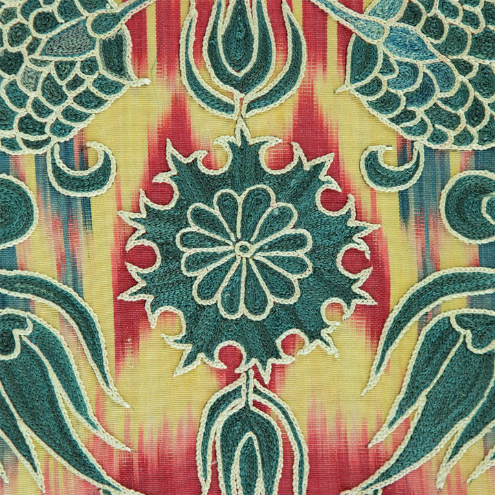 Close up view of Mekhann's multicoloured and teal silk artwork, displaying the finesse of the gold thread against the vivid colour palette, highlighting the teal embroidery against a colourful background.