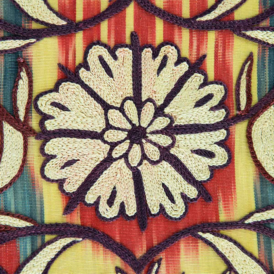 Close up view of Mekhann's multicoloured and cream silk artwork, showcasing one of the cream floral motifs with a dark purple outline.