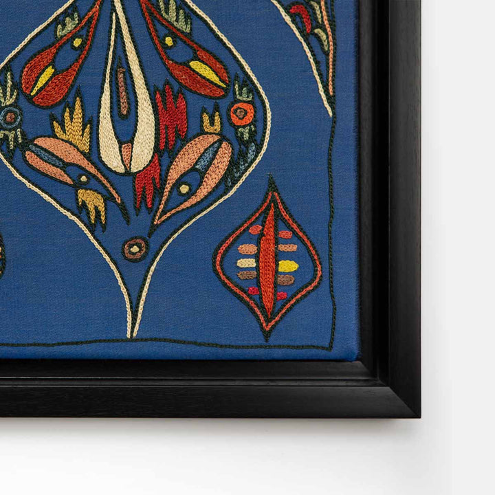 Corner view of Mekhann's navy silk hand embroidered artwork, showing the edge of the black frame and how it makes the navy colour stand out.