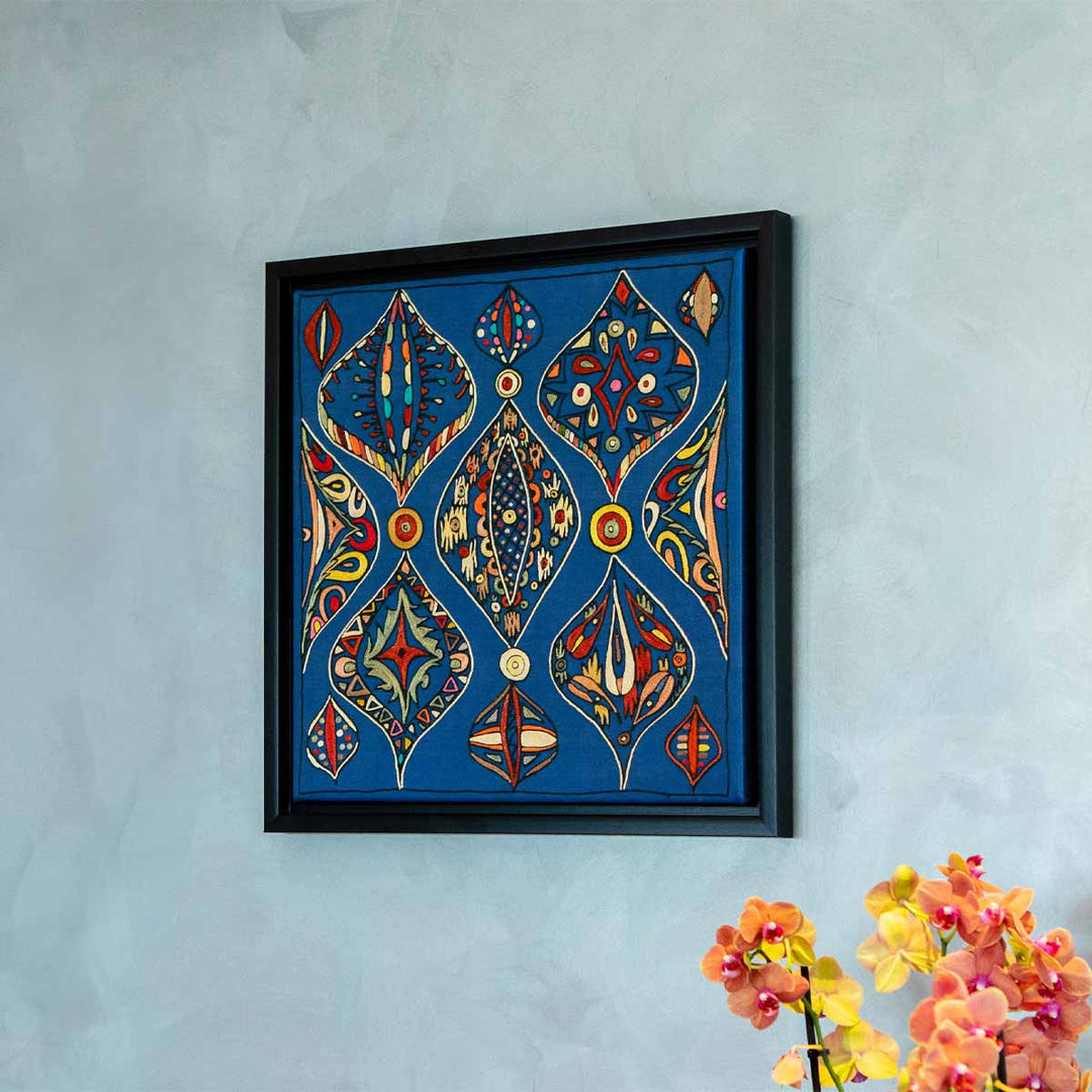 In use view of Mekhann's navy silk hand embroidered artwork, shown hung on a wall to give a size context.