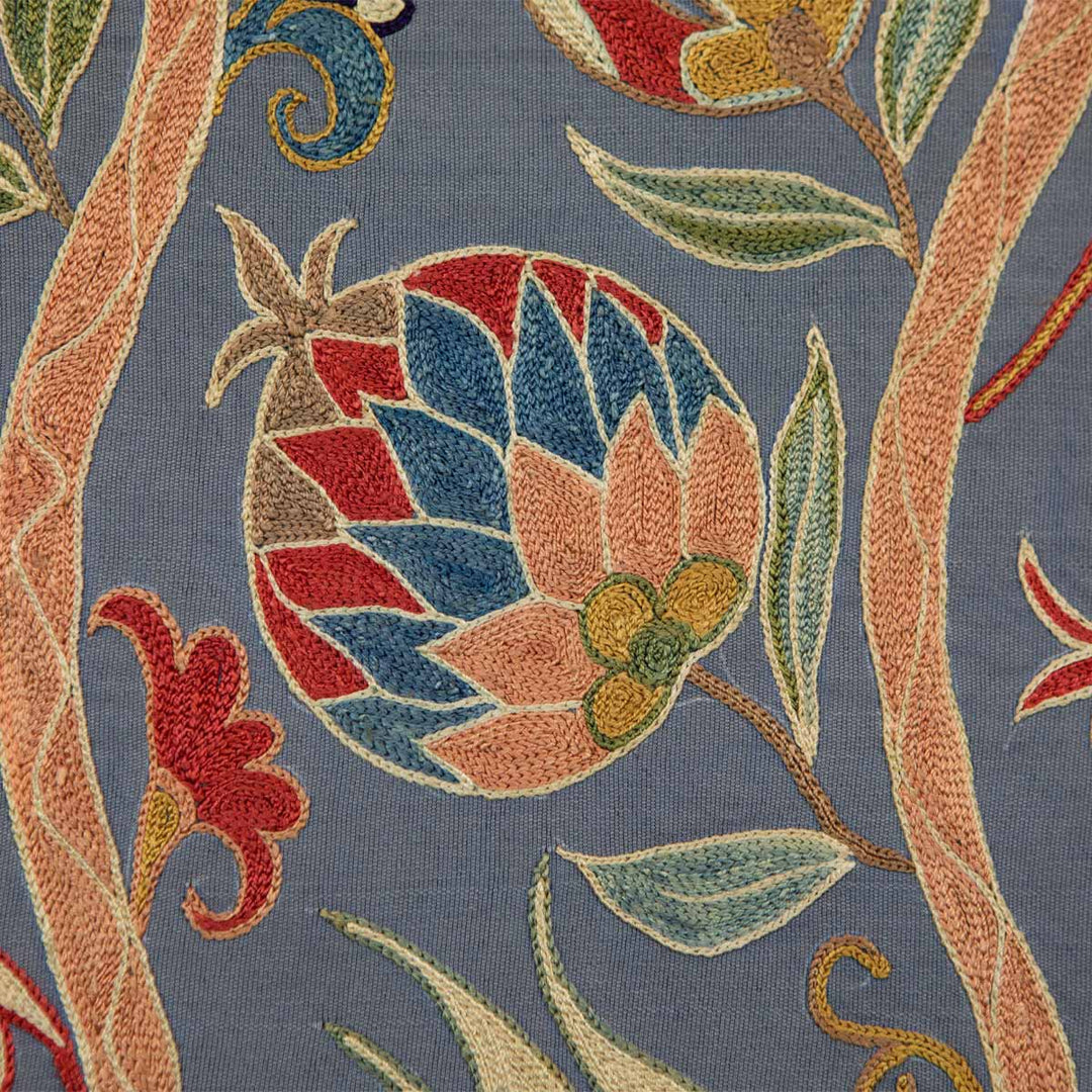 Close up view of Mekhann's navy silk botanicals artwork, focusing on the fine details of the fruit and vine motifs, the richness of the colours, and the texture of the embroidery .