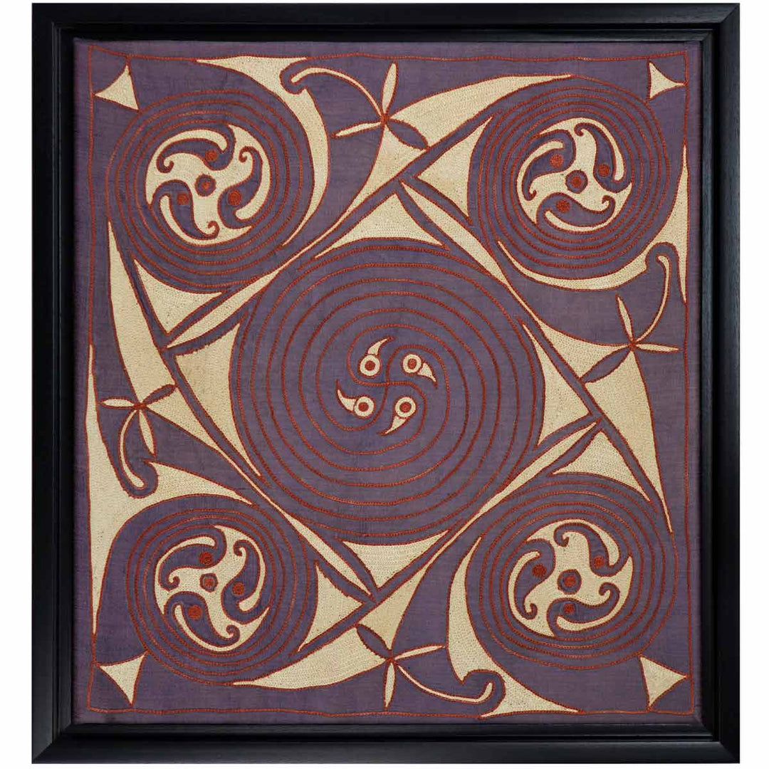 Front view of Mekhann's purple silk embroidered spirals artwork, displaying purple spirals geometric pattern in cream, red, on a base of purple silk, in a black frame.
