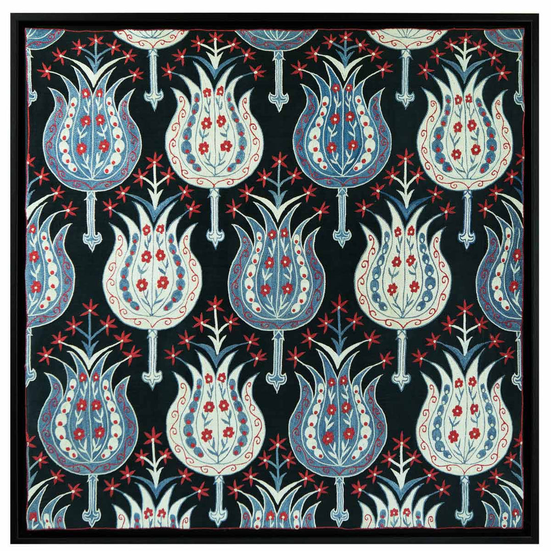 Front view of Mekhann's black silk hand embroidered garden artwork, with a collection of hand embroidered flowers in light blue and white with red detailing, all against a black silk background. All of this within it's black frame to match with the black silk base.