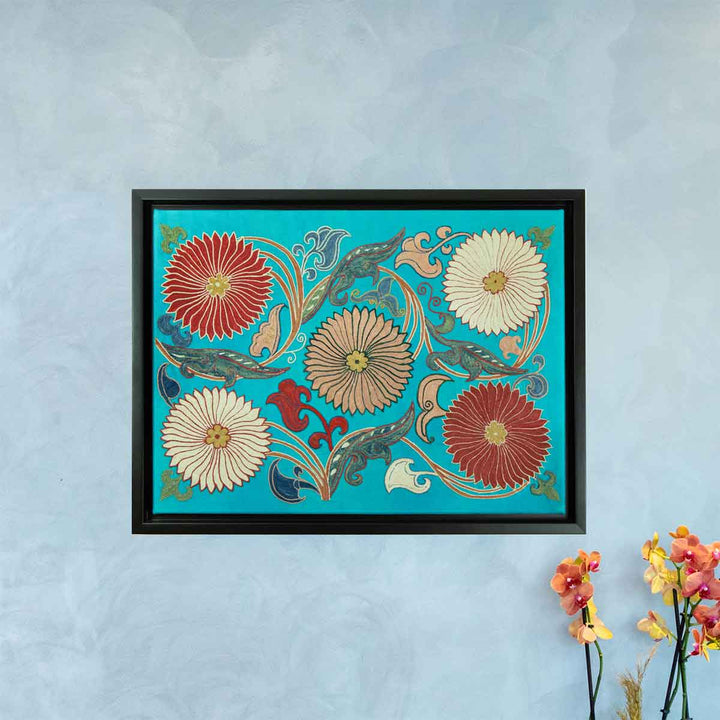 In use view of Mekhann's hand embroidered, turquoise silk artwork, featuring a vibrant turquoise silk background with hand embroidered flowers and swirling vines in red, cream and beige.