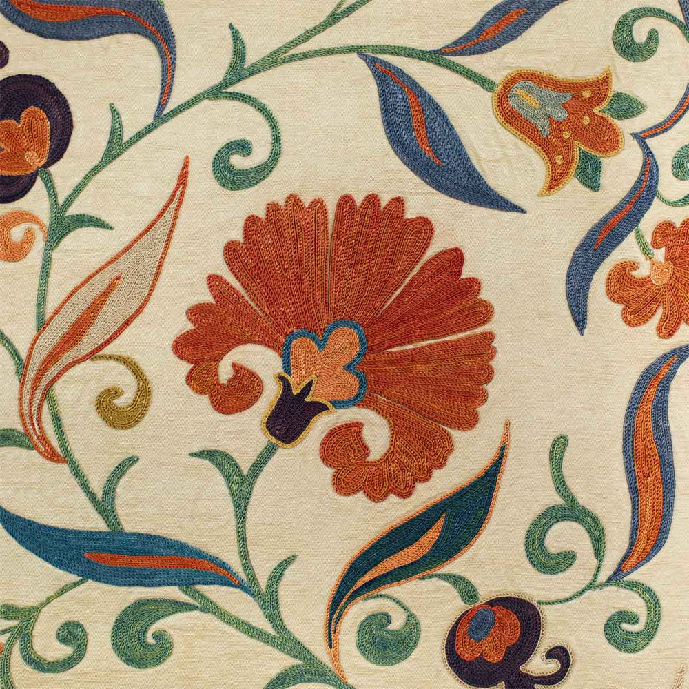 Close up view of Mekhann's cream ottoman vines runner, showing a close up of the orange carnation motif, hand embroidered with silk yarns on a base of cream coloured silk.
