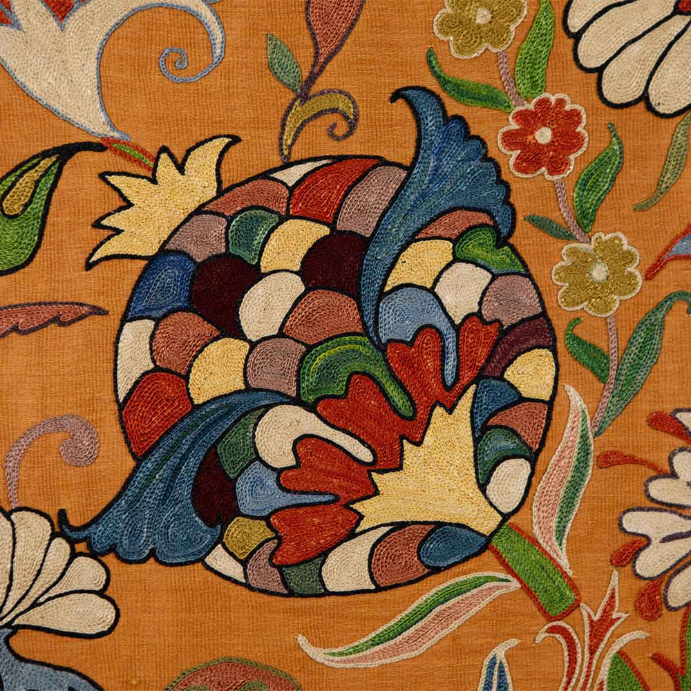 Close up view of Mekhann's caramel iznik petite throw, with Intricate embroidery details on Mekhann's caramel throw, displaying traditional Iznik motifs with a blend of geometric shapes and floral accents.