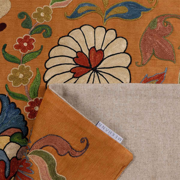 Folded view of Mekhann's caramel iznik petite throw, showing the back lining fabric to the throw with the Mekhann label in the image.