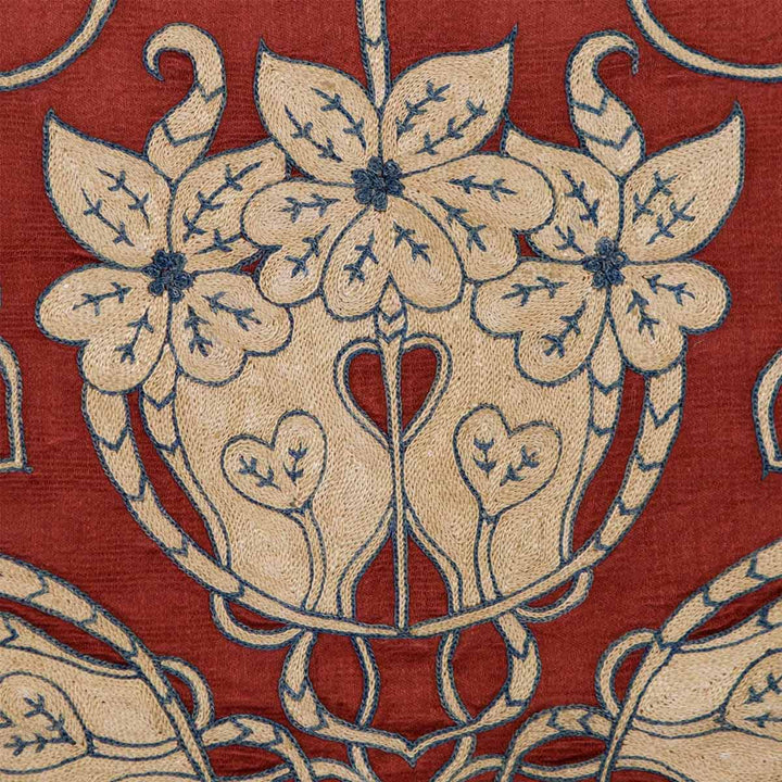 Close up view of Mekhann's maroon baroque petite throw, showing the elaborate cream baroque embroidery against the maroon silk background, a testament to exquisite artisanal skill.