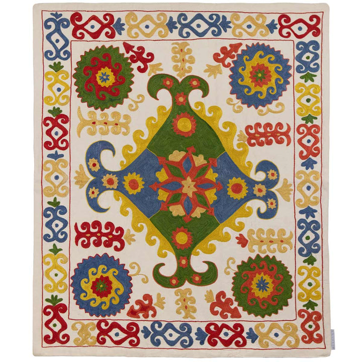 Front view of Mekhann's multicoloured arabesque petite throw, an elegant cream coloured throw with vibrant embroidered patterns, all of which have been hand embroidered using silk yarns onto a canvas of cream silk fabric.