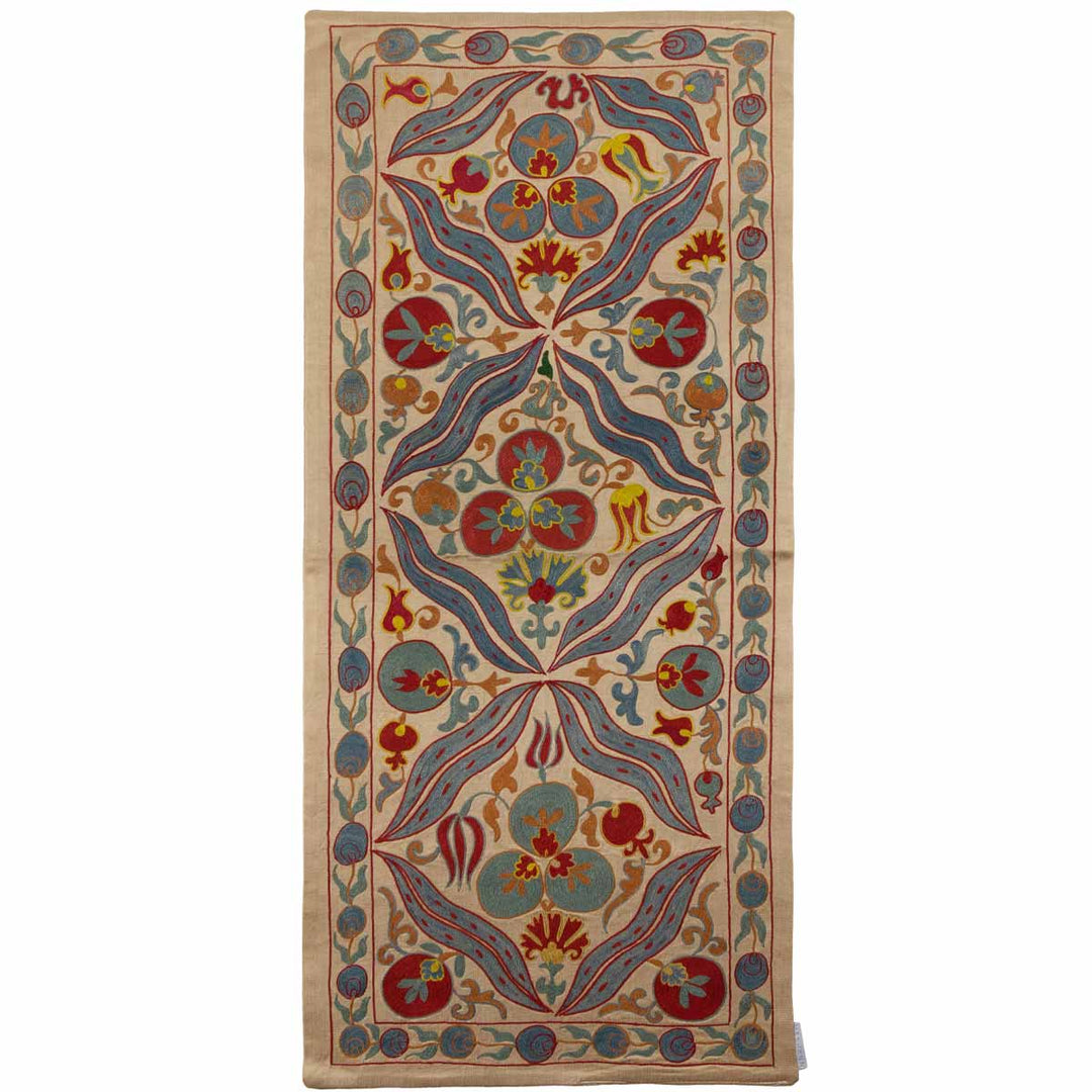 Front view of Mekhann's multicoloured cintamani runner, showing the traditional hand embroidered cintamani patterns surround by other decorative elements in colours blue, red, and orange set on a base of cream coloured silk.