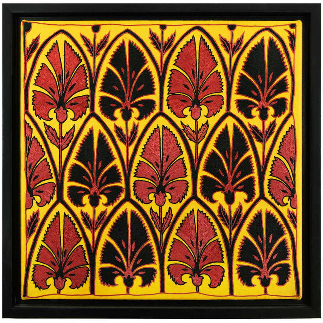 Front view of Mekhann's yellow silk artwork with black and red embroidered patterns, featuring a vivid yellow background with symmetrical black and red decorative patterns, all within a black frame.