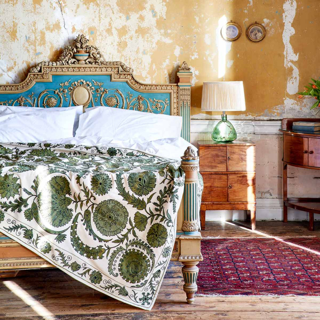 In use view of Mekhann's emerald botanical throw, showing the green botanical throw on the foot of a bed.