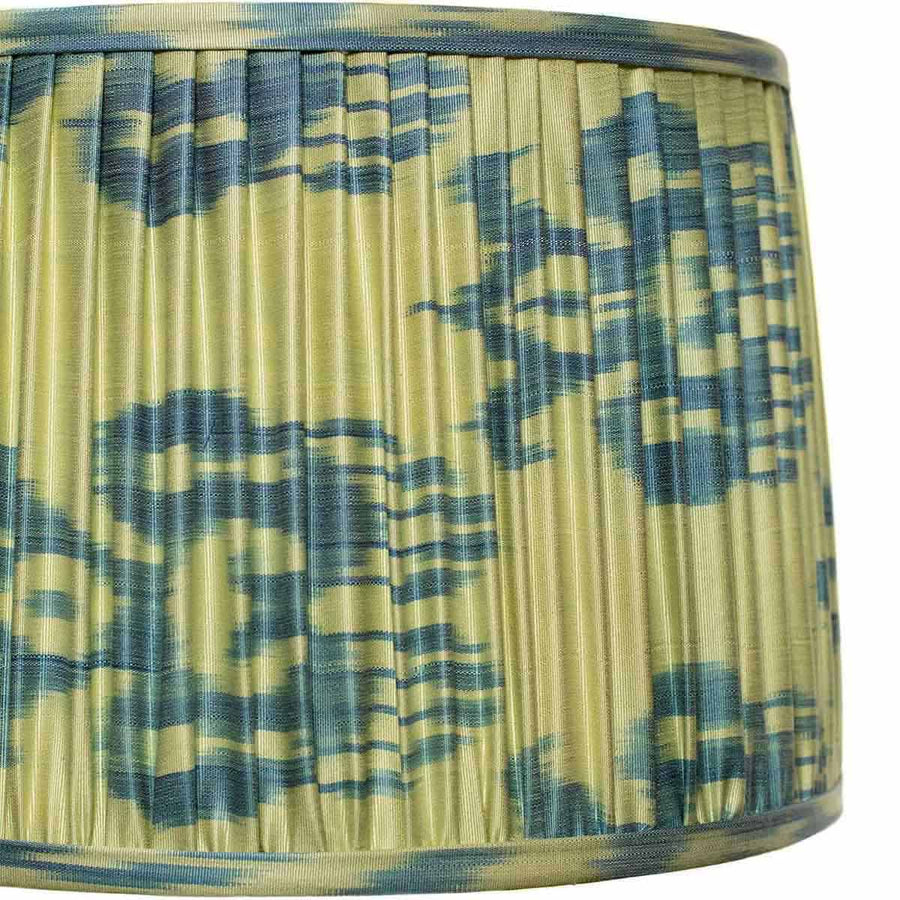 Close-up of Fleur’s pleated ikat silk, blue-green floral motif and fabric-covered binding.