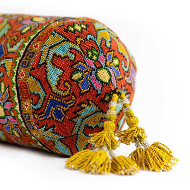 Bottom view of Mekhann's orange embroidered floral bucket bag, displaying the consistent floral pattern all across the bag.