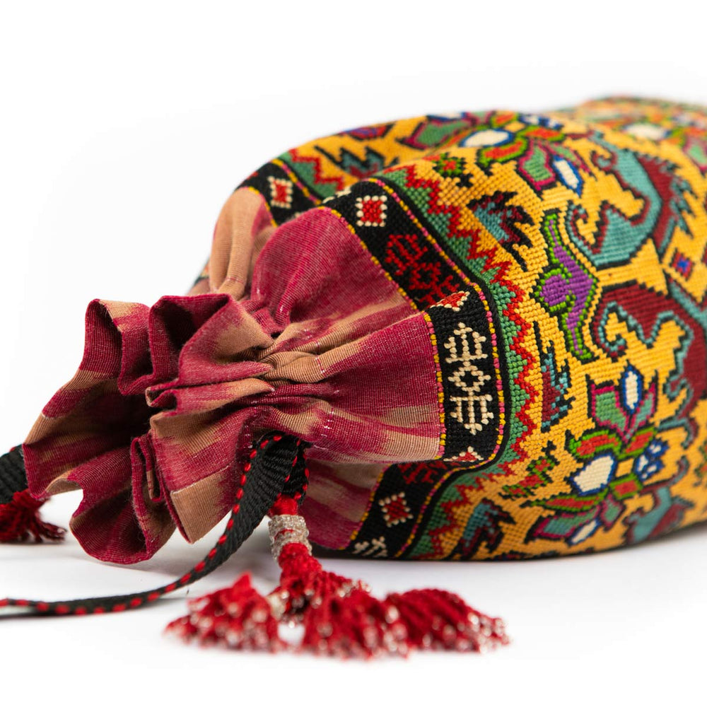 Top view of Mekhann's multicoloured embroidered floral bucket bag, showcasing the closing feature the bag has. 