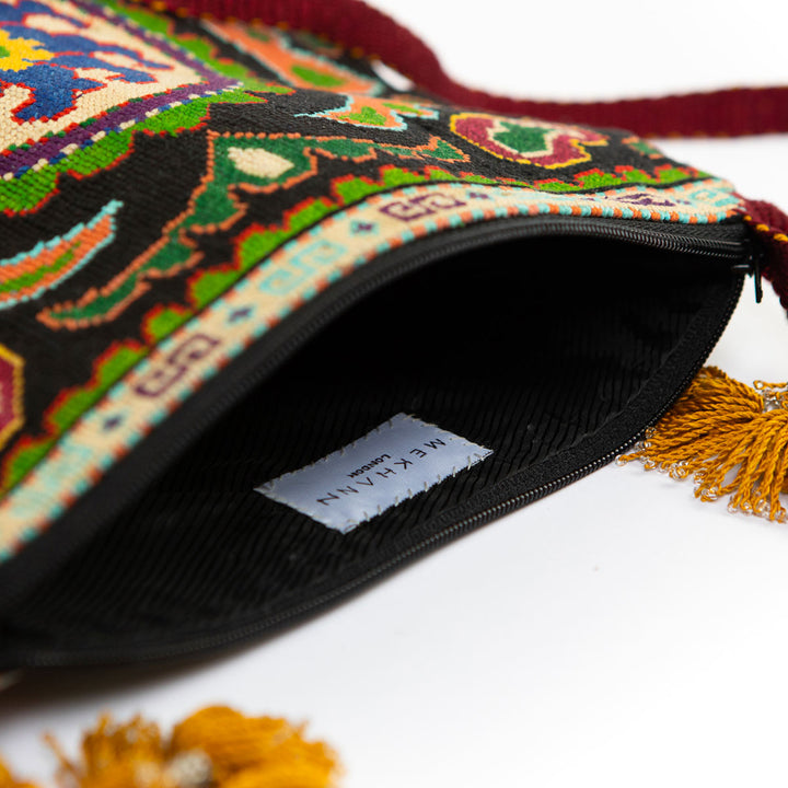 Inside view of Mekhann's black and multicoloured floral embroidered cross-body, showing the black durable lining fabric.