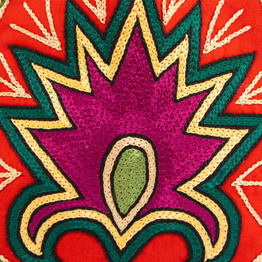 Close up view of Mekhann's floral light maroon velvet pouch, a colourful display of the cross stitch method used to create the surface design patterns.