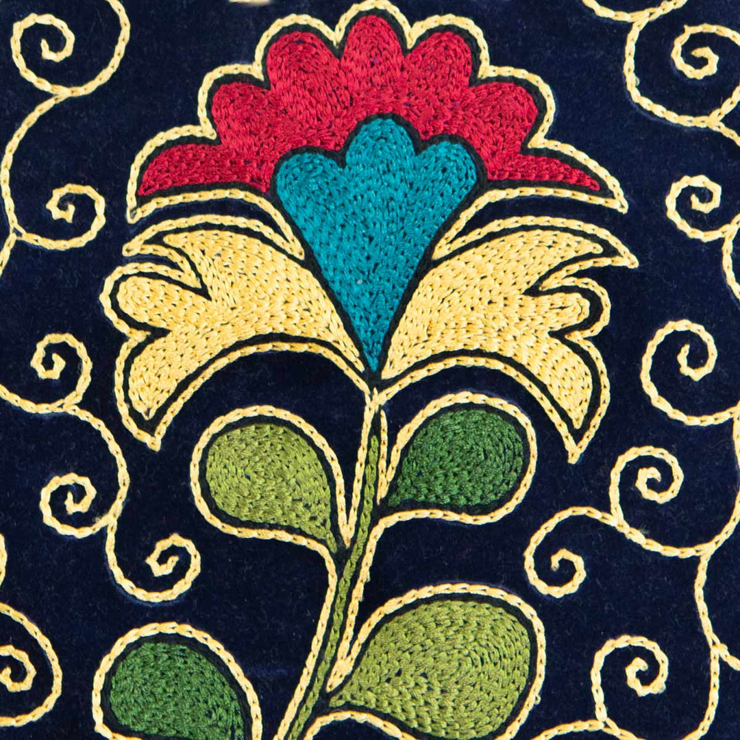 Close up view of Mekhann's floral navy velvet pouch, showing off the detailed silk embroidered flower and surrounding patterns.
