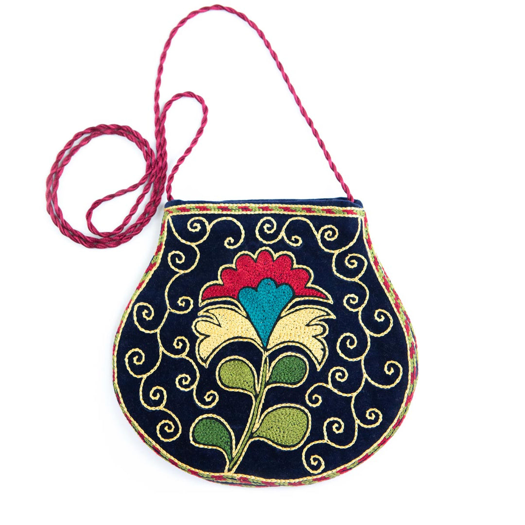 Front view with strap of Mekhann's floral navy velvet pouch, showing off the delicate pink strap. 