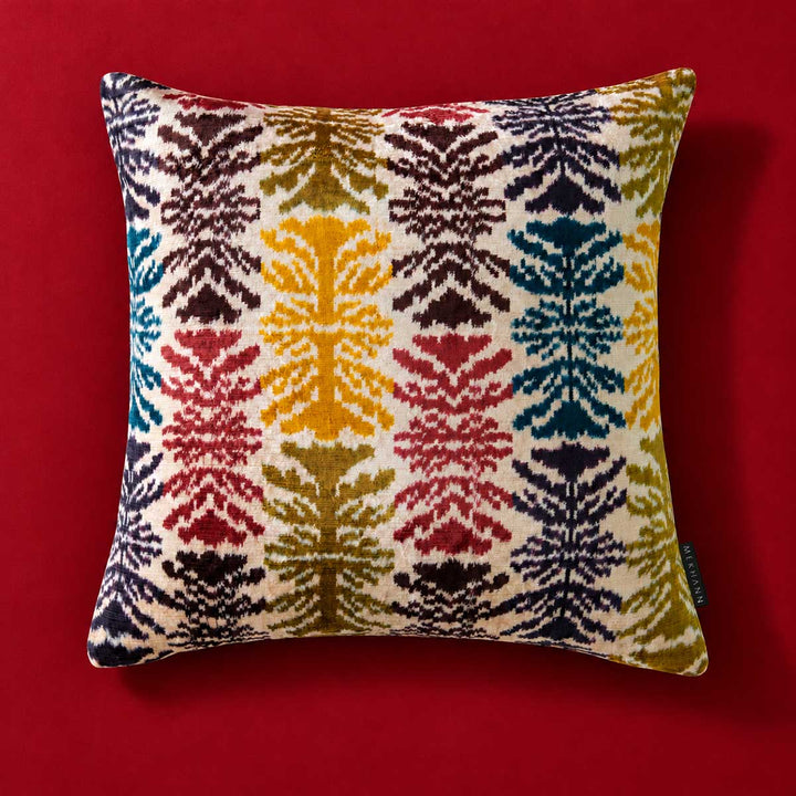 Front view of the Frond Cushion in Ivory against a red background. 