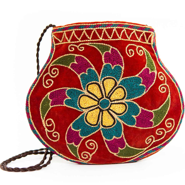 Front alternative view of Mekhann's geometric light maroon velvet pouch, showing the delicate strap against the vibrant maroon.