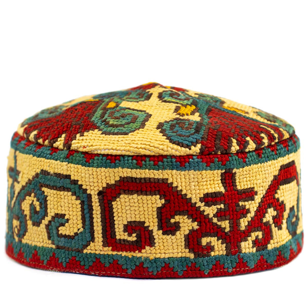 Front view of Mekhann's geometric cream skull cap, displaying a bright range of embroidered geometric patterns on a cream base.