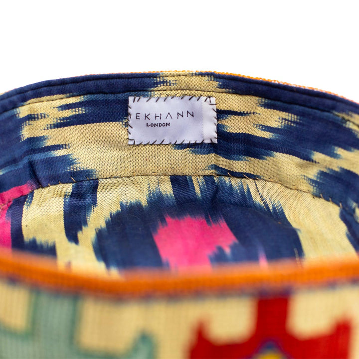 Inside view of Mekhann's geometric cream skull cap, showcasing a vibrant blue, pink, and cream ikat lining for style and durability.