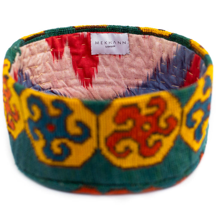 Full frame view of Mekhann's geometric green skull cap, showcasing the wonderful ikat lining interacting with the embroidery of the exterior.