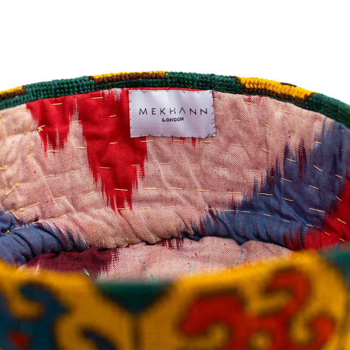 Inside view of Mekhann's geometric green skull cap, showcasing the ikat lining and the hand stitched detailing, representing Mekhann's attention to detail. 