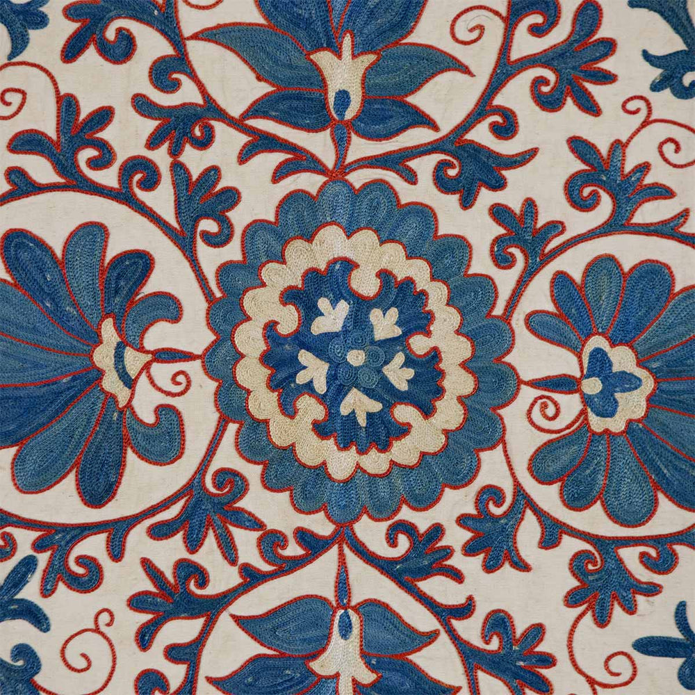 Close up view of Mekhann's cream iznik petite throw, highlighting the texture of the woven fabric and the vibrant, contrasting embroidery that draws inspiration from traditional Iznik ceramics.
