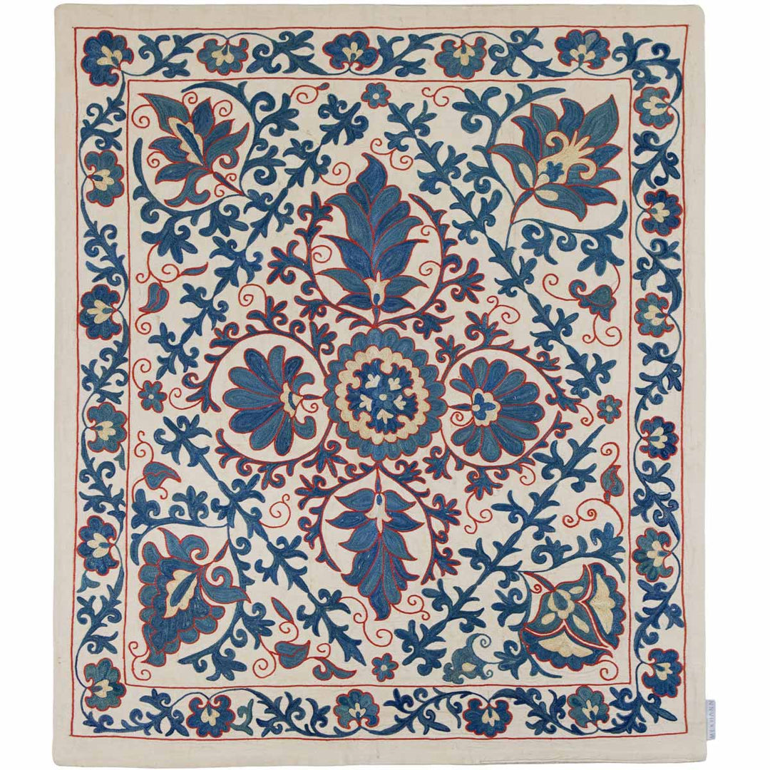 Front view of Mekhann's cream iznik petite throw, with a central medallion surrounded by floral patterns in shades of blue and coral, set against a cream silk backdrop.