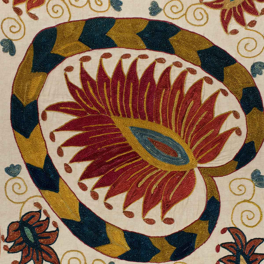 Close up view of Mekhann's cream lotus runner, showcasing the attention to detail in the embroidered patterns of the lotus runner., hand embroidered in red, dark yellow, and red as the stand outs. 