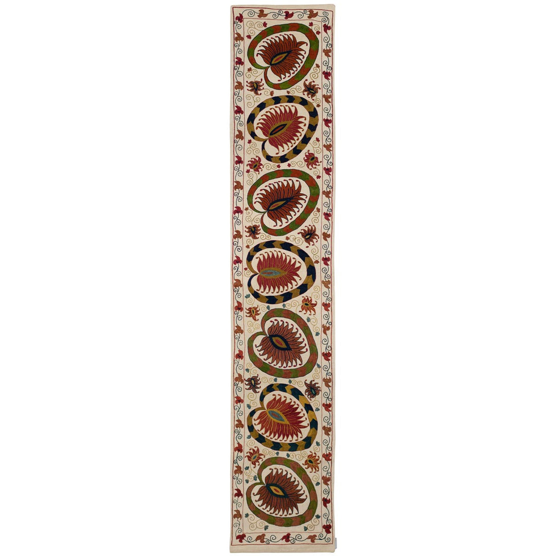 Front view of Mekhann's cream lotus runner, showing in full the hand embroidered lotus patterns in warm earthy hues embroidered onto a canvas of cream coloured silk.