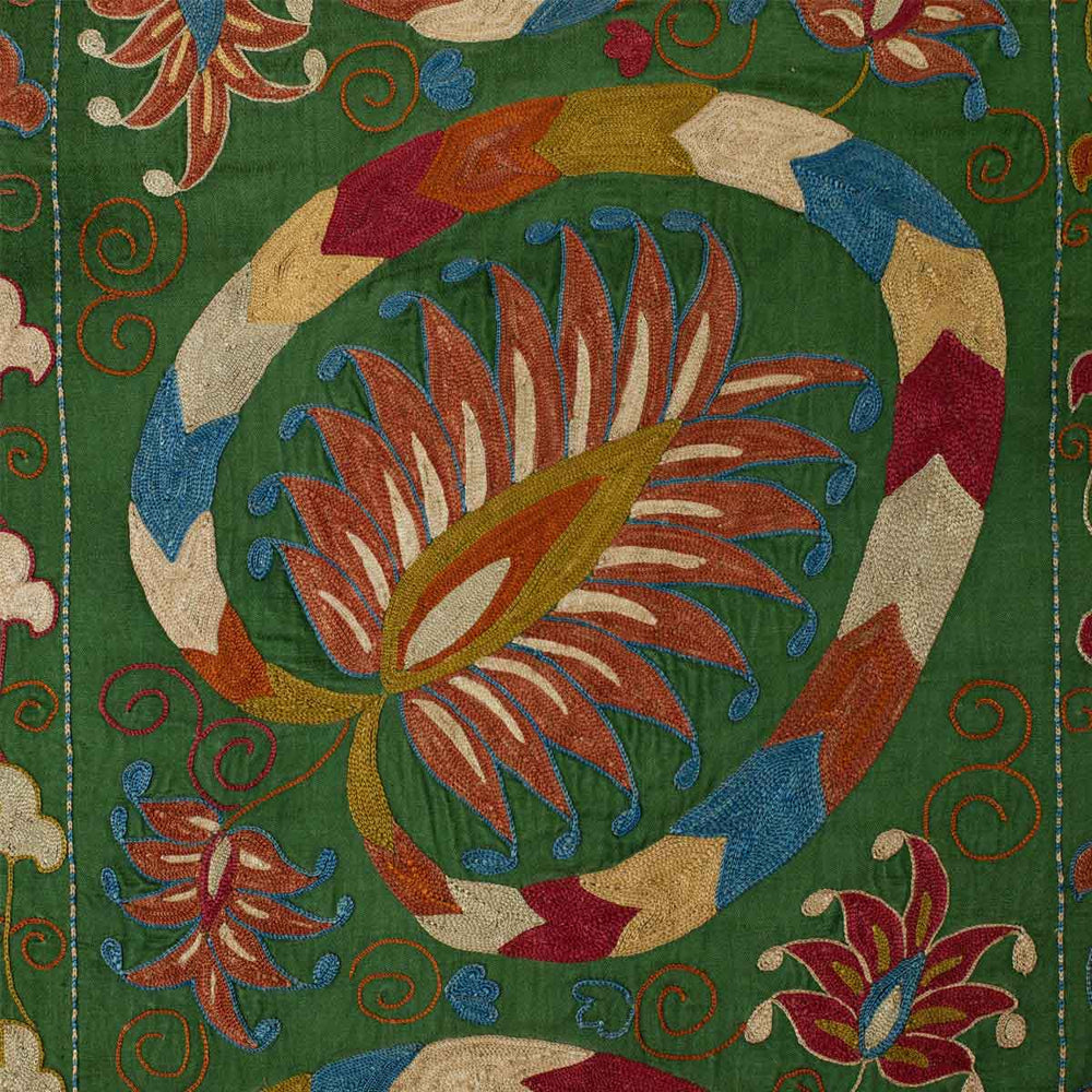 Close up view of Mekhann's green lotus runner,  shown the hand embroidered lotus pattern on a backdrop of green silk.