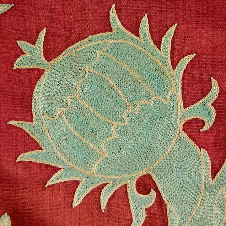 Close up view of Mekhann's maroon grape vines throw, showing a light blue design motif with a light cream outline to make it stand out against the maroon silk background.
