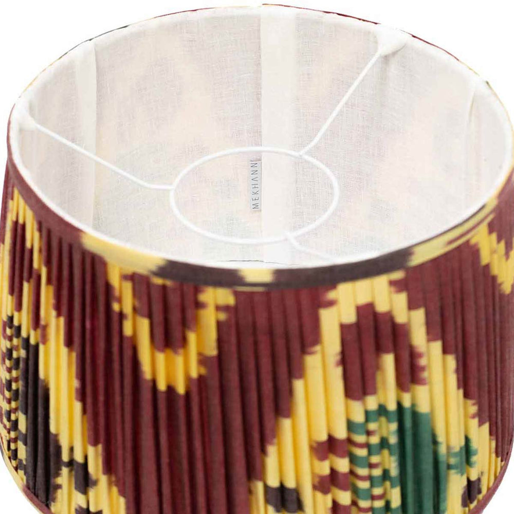 Interior view of Mekhann's hand-pleated silk lampshade, featuring a maroon base with a lively multicolour ikat pattern.